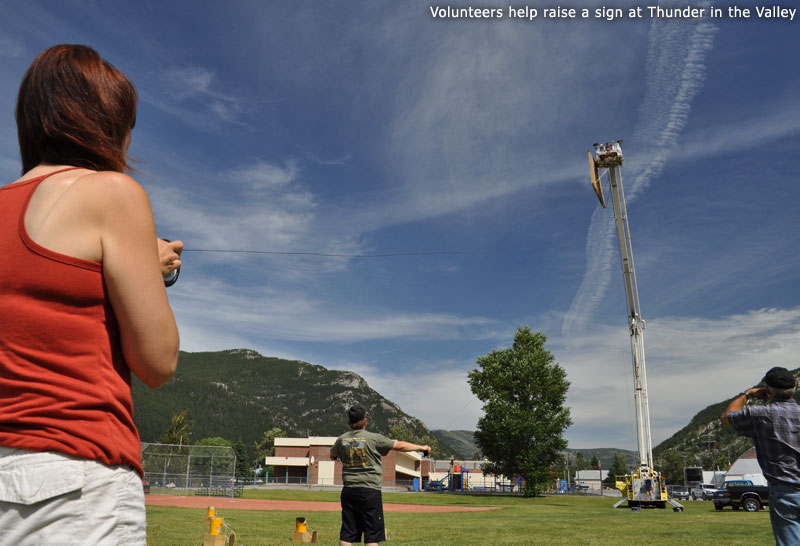Volunteers help raise a sign at Thunder in the Valley
