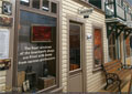 The front windows of the boardwalk shops are filled with items from various professions